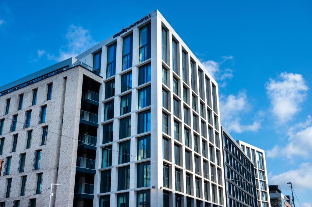 都柏林Staycity Aparthotels Dublin City Quay的一座以蓝天为背景的办公楼