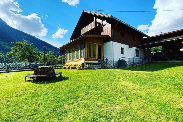 大基希海姆Chalet in Grosskirchheim in Carinthia with sauna的草地前有长凳的房子