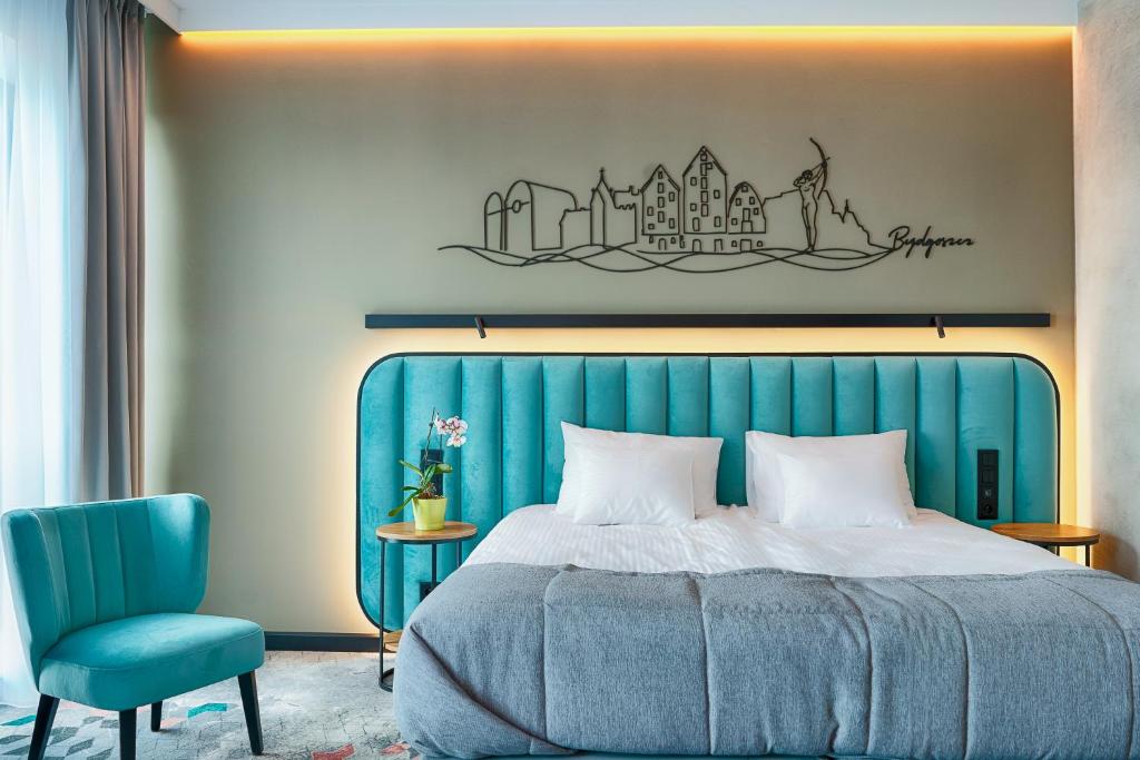 比得哥什Focus Hotel Premium Bydgoszcz的一间卧室配有蓝色的床和蓝色椅子