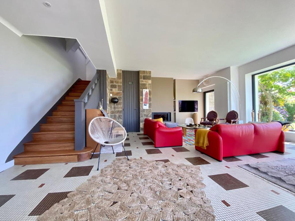 贝诺代Superbe villa vue sur mer, corniche de la plage的一间带红色家具和楼梯的客厅