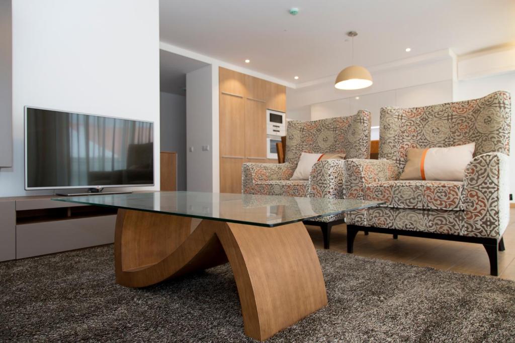 纳扎雷Apartamentos Turisticos da Nazare的客厅配有玻璃桌和沙发