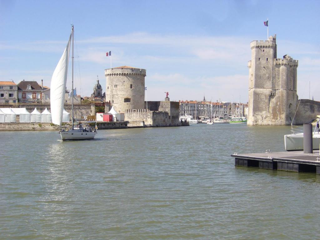 拉罗谢尔Joli studio meublé + parking en sous sol的城堡旁边的水中帆船