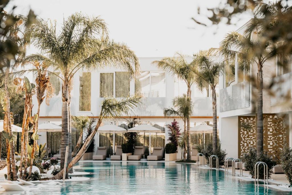 LalëzElite Bay Hotel Lalez Durres的一座拥有游泳池和棕榈树的酒店