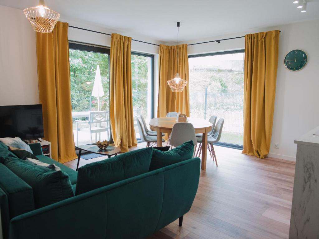 乌斯特龙Apartament Nad Strumykiem z ogródkiem - Dream Apart的客厅配有绿色沙发和桌子