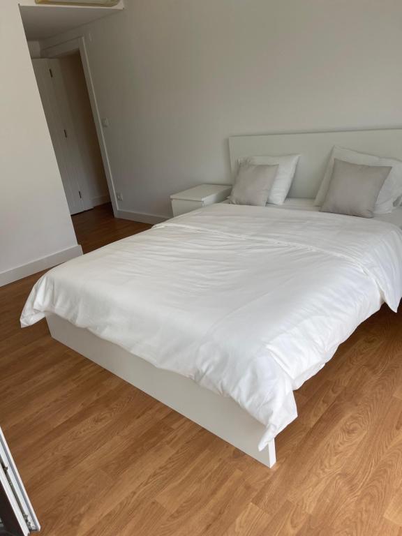 里斯本理想方向的一张白色大床,配有白色床单和枕头