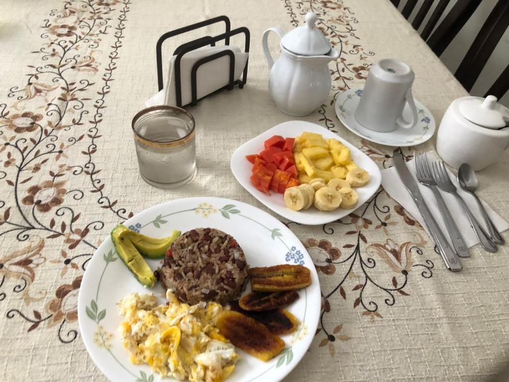 Santiago EsteRoom near Airport/ Cerca del Aeropuerto的一张桌子,上面有两盘早餐食品