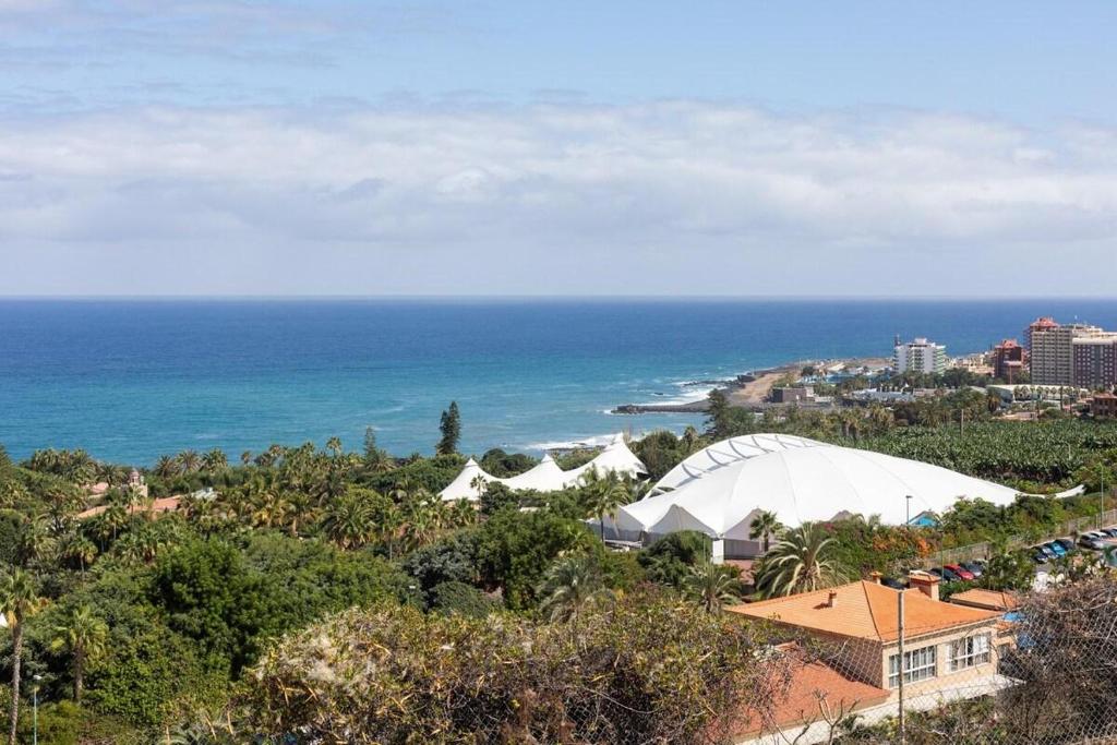 拉克鲁斯Prime Homes Playa Jardin Studio的享有大海和海滩的景色,设有一座建筑