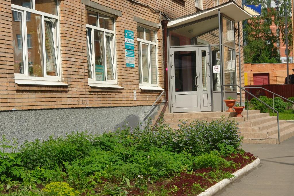 彼得罗扎沃茨克Karelrepostrebsoyuz Hostel的砖屋,有白色的门和楼梯