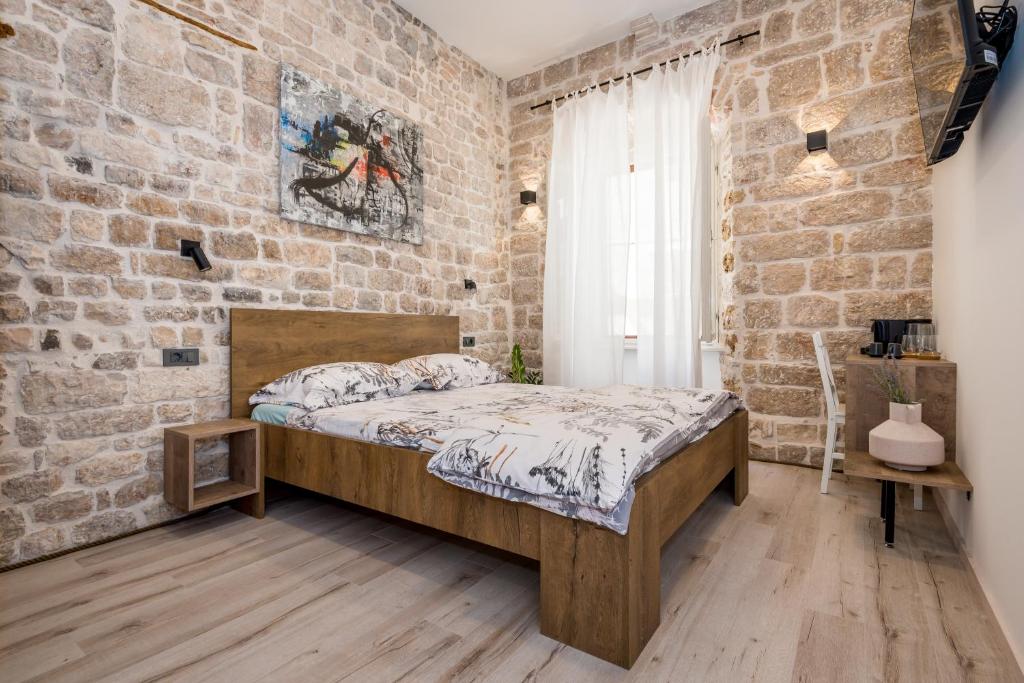 希贝尼克House Poletti的卧室设有砖墙,配有一张床