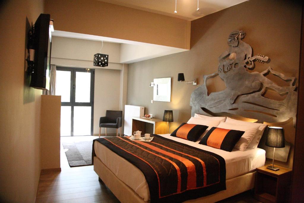 斯泰尼杜伊费奥斯木斯克潘多克西奥旅馆的卧室配有一张大床,墙上有雕塑