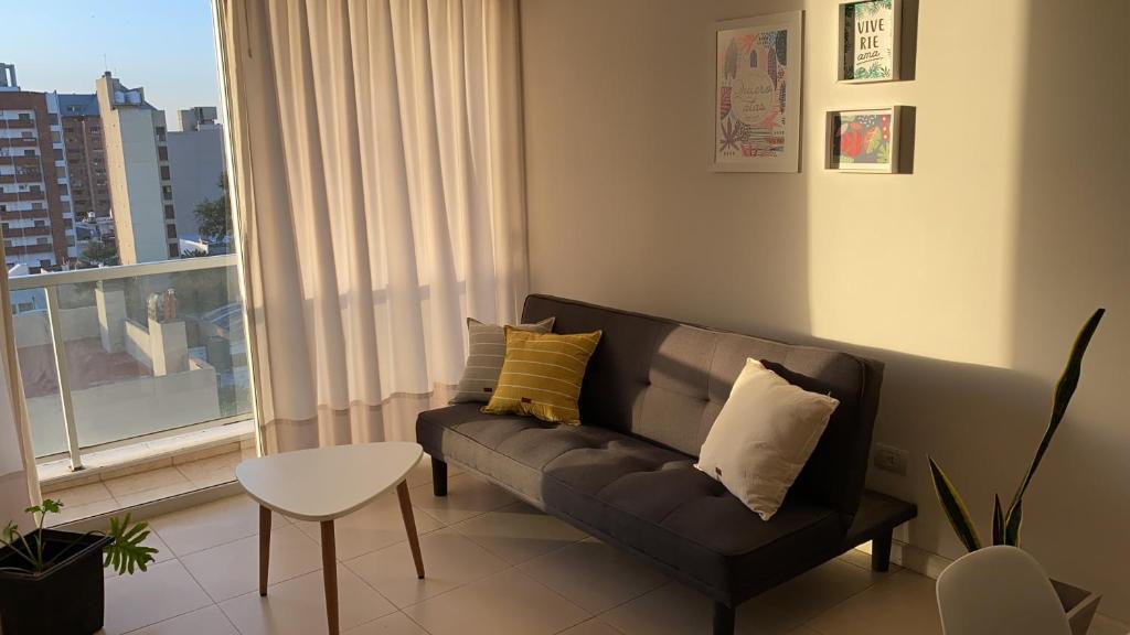 里奥夸尔托Departamento céntrico - Leer condiciones y precio的带沙发和窗户的客厅