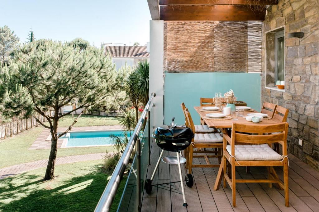 卡瓦利亚尔Sea Spot Soltróia的一个带桌椅和烧烤架的庭院