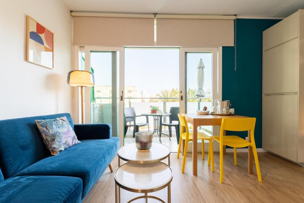 英格兰海滩Trendy, very well located apartment的客厅配有蓝色的沙发和桌子