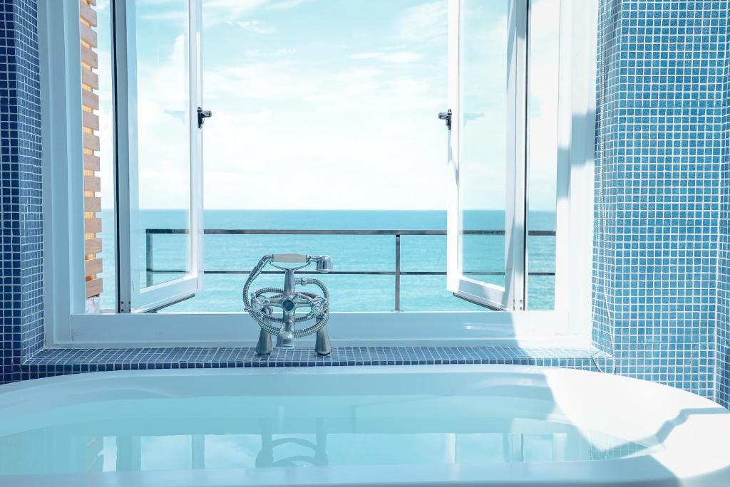 鹅銮鼻垦丁伯利恒民宿的带浴缸的浴室,享有海景。