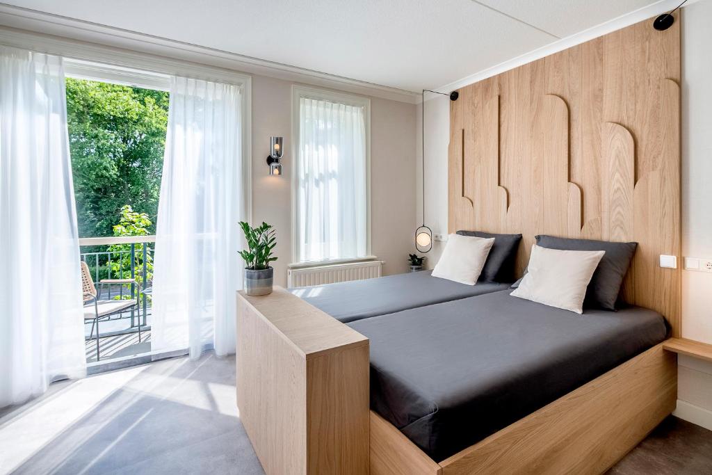 栋堡B&B Hotel Villa Vida的一间卧室配有一张带木制床头板的床和窗户。