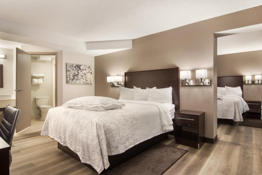 伊利Red Roof Inn PLUS & Suites Erie的酒店客房带两张床和一间浴室