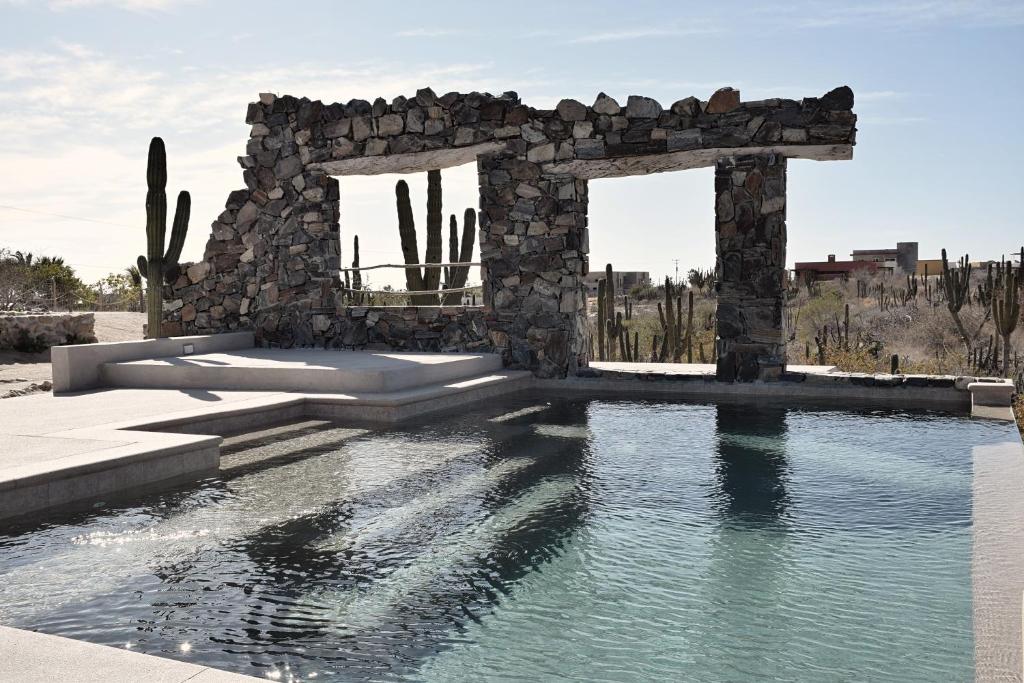 托多斯桑托斯Desierto Azul的一座带游泳池的石头建筑的 ⁇ 染