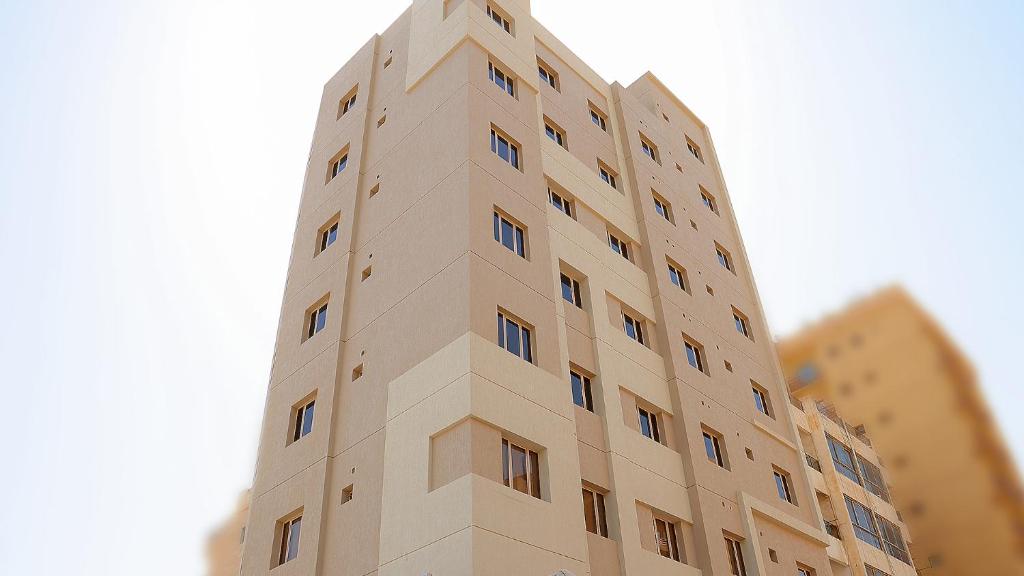 科威特BHomed Furnished Apartments的一座高大的棕褐色建筑,其一侧设有窗户