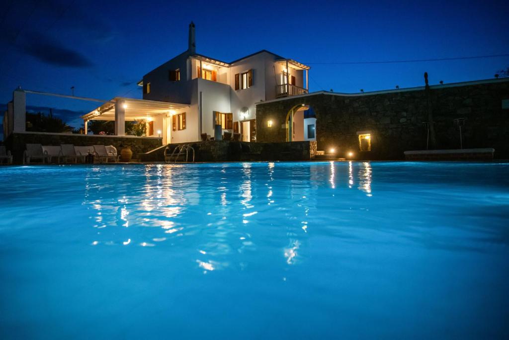 阿诺梅拉Villa Dimitra的游泳池,后方是一座房子