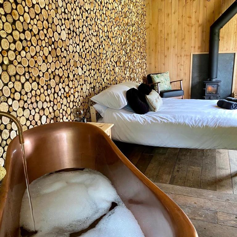 蒙默思Bee Bole Cabin的卧室配有一个充满雪的浴缸和一张床