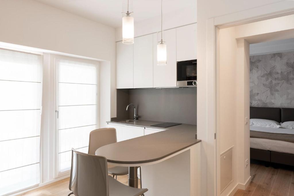 贝卢诺Casa Fullin的厨房配有白色橱柜和桌椅