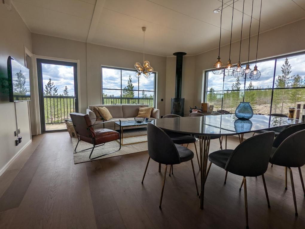 伊德勒Poolorama Lodge - with magnificent mountain view的用餐室以及带桌椅的起居室。