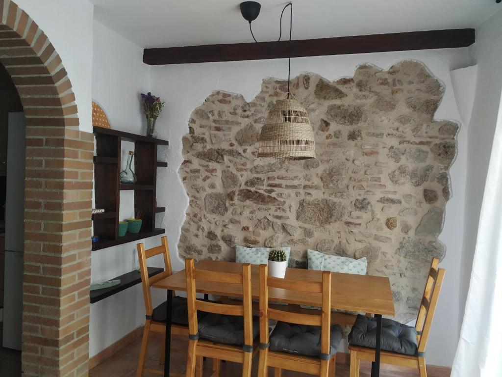 桑特费柳德吉克索尔斯Pis a Sant Feliu de Guíxols的一间设有石墙和桌椅的用餐室