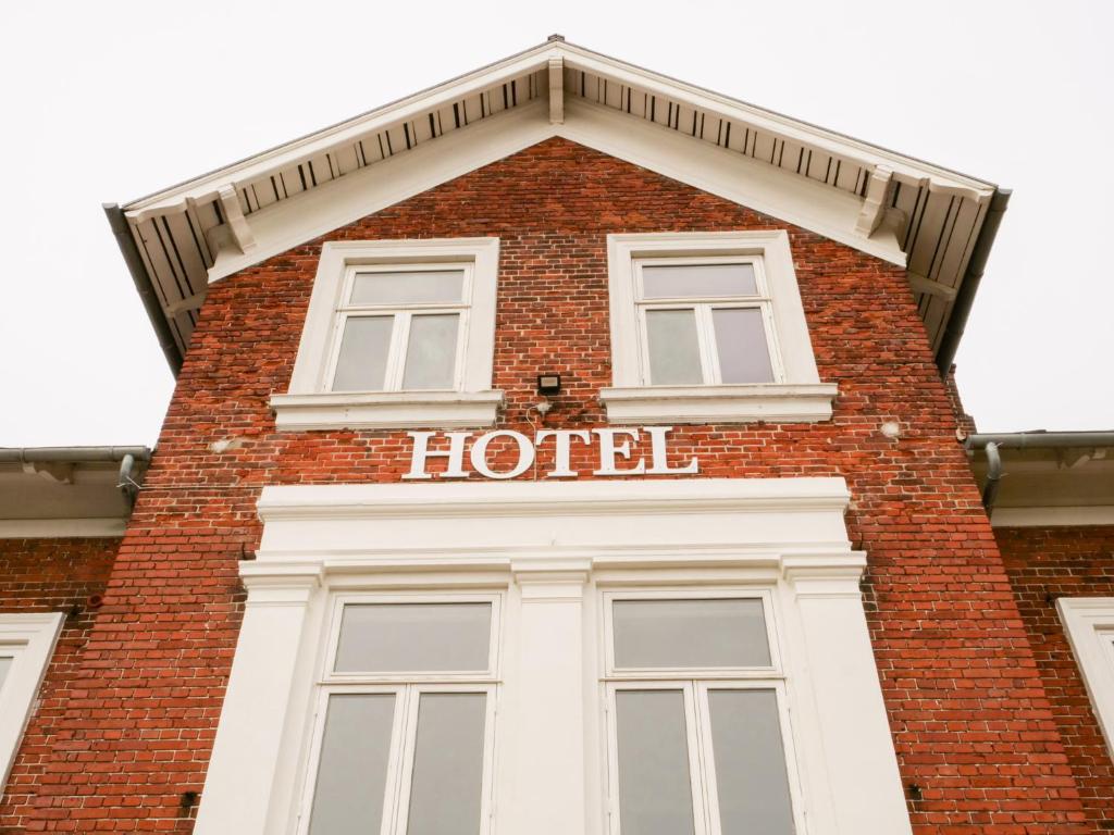 尼堡Hotel Villa Gulle的一座高大的砖砌建筑,上面有酒店标志