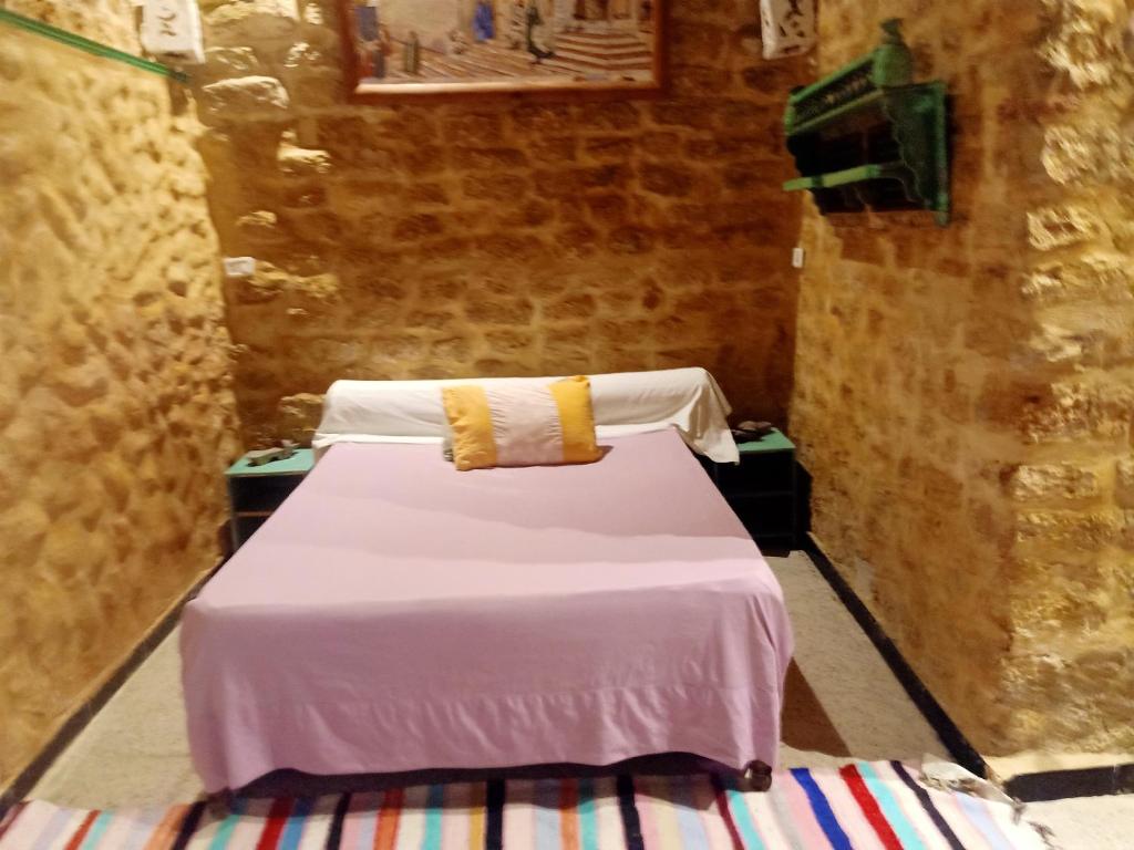 突尼斯2 bedrooms apartement with city view furnished terrace and wifi at Tunis 4 km away from the beach的一间卧室配有带白色床单和黄色枕头的床。