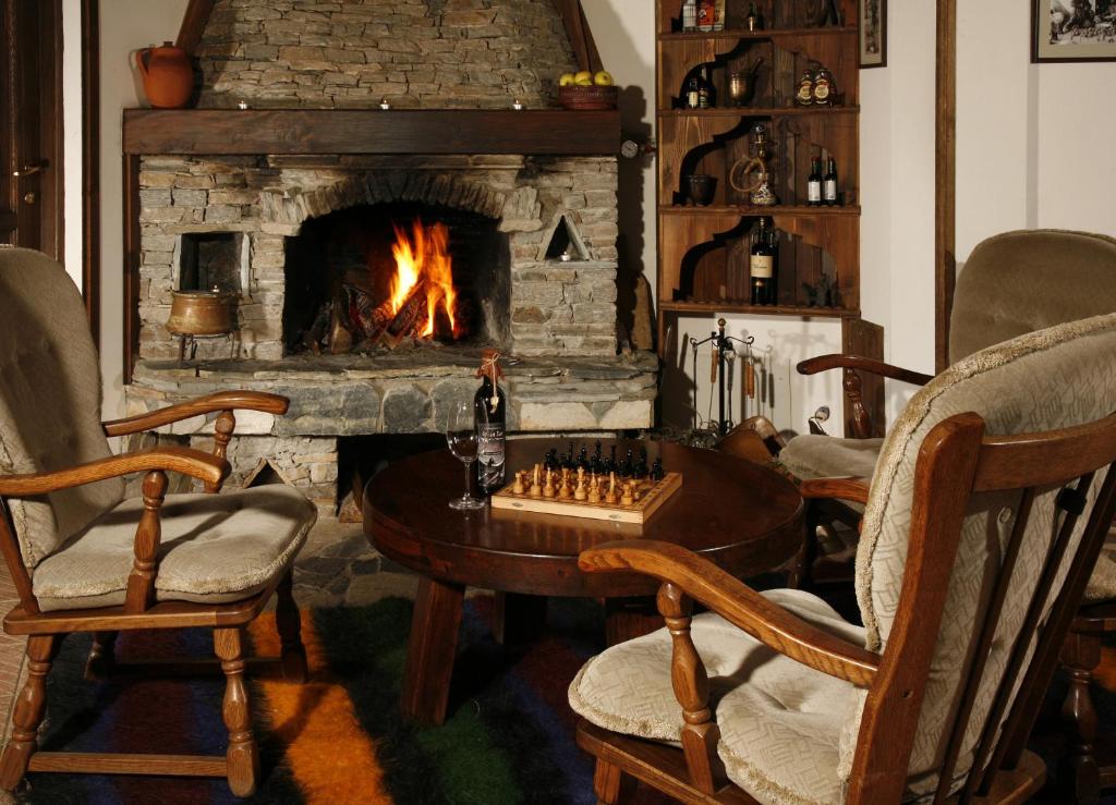 特里格拉德阿尔坎韩酒店的客厅设有壁炉、棋盘和椅子