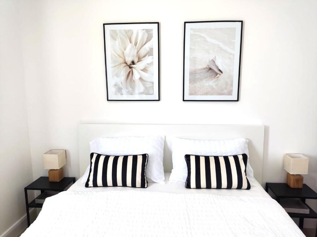 耶尔萨Mina Lux Jelsa的卧室配有一张白色床,墙上挂有两张照片