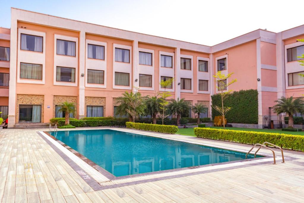 新德里提沃里格兰德度假酒店的建筑前的一座带游泳池的建筑