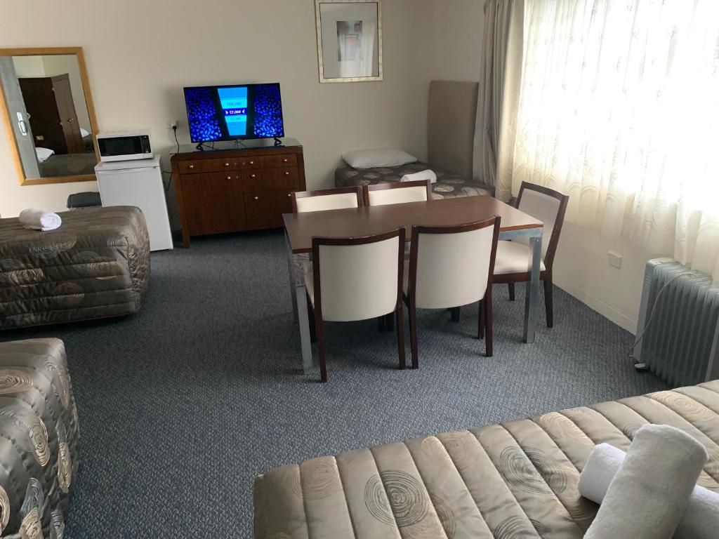 奥伯伦提塔尼亚汽车旅馆的客厅配有桌椅和沙发