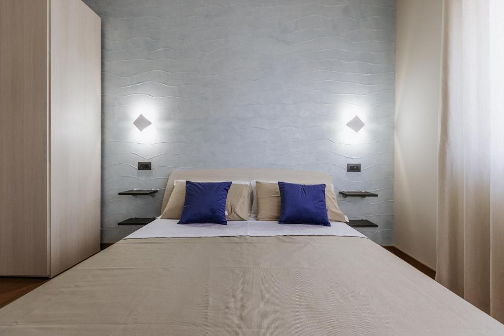 巴里APULIA BLUE APARTEMENTS & B&B的一间卧室配有一张带蓝色枕头的大床