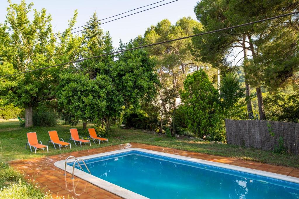 San Pedro de RiudevitllesMasia Can Comas的一个带两把椅子的庭院内的游泳池