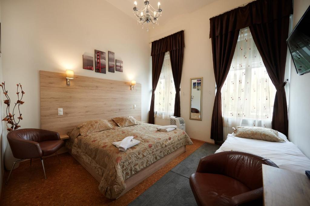 松博特海伊Vinci Apartman Szombathely的一间卧室配有两张床和吊灯。