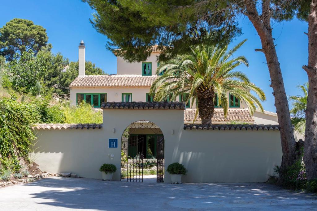 贝尼萨Villa Riu Blanc的一座带大门和棕榈树的房子