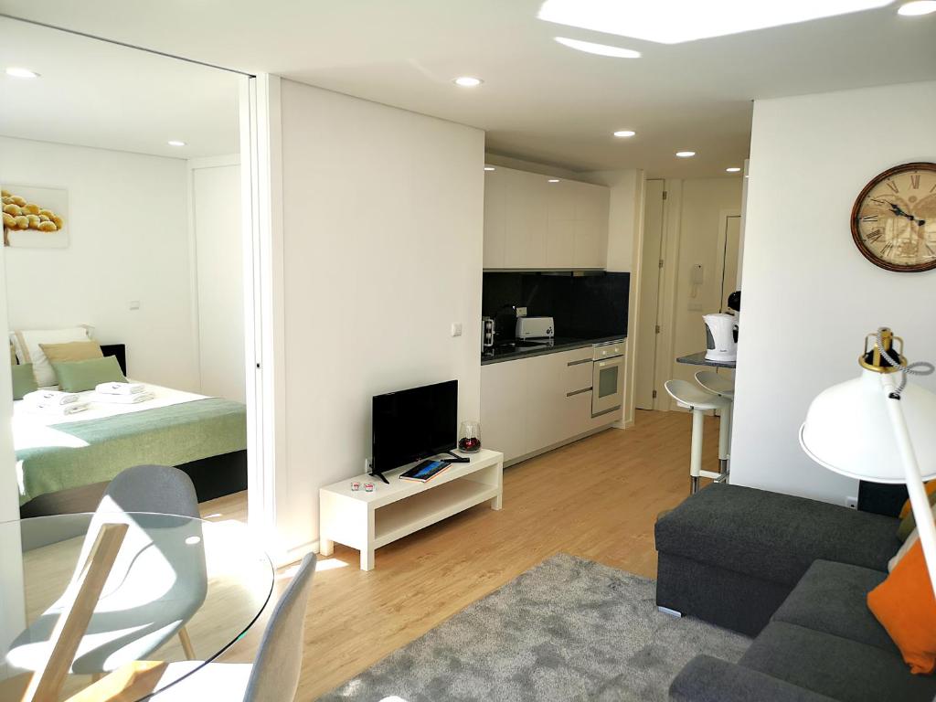 波尔图OportoView Prestige Apartment的一间带一张床的房间和一间带镜子的客厅