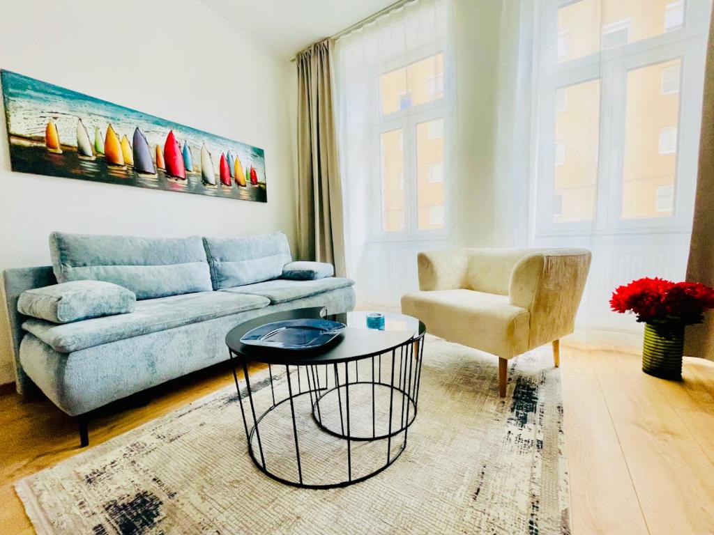 维也纳Colorful & Quiet Apartment in Beautiful Viennese Building的客厅配有蓝色的沙发和椅子
