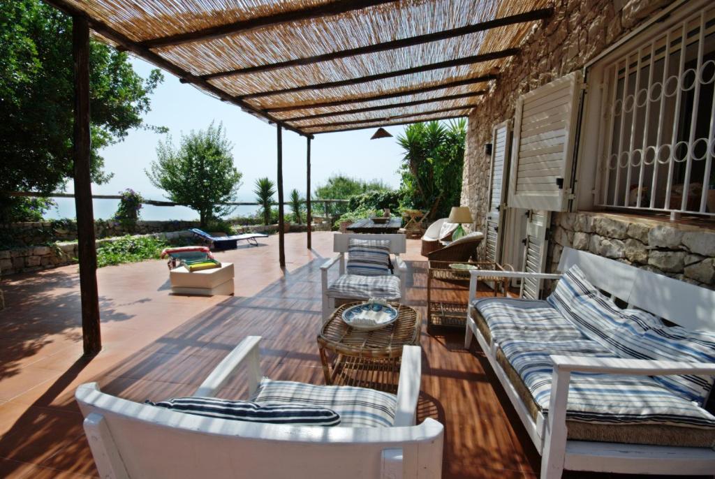 加利亚诺德尔卡波TRULLO MEDITERRANEO - SANTA MARIA DI LEUCA的木制甲板上配有沙发和椅子的庭院