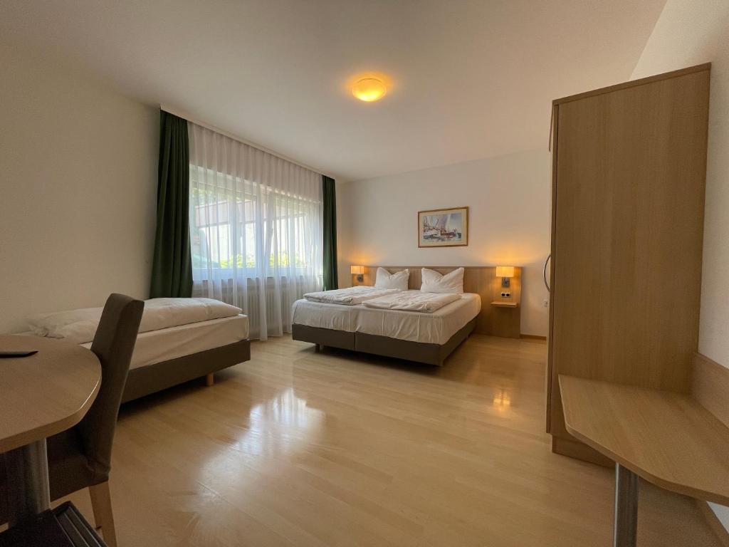 斯图加特Hotel Hafner的酒店客房设有两张床和一张桌子。