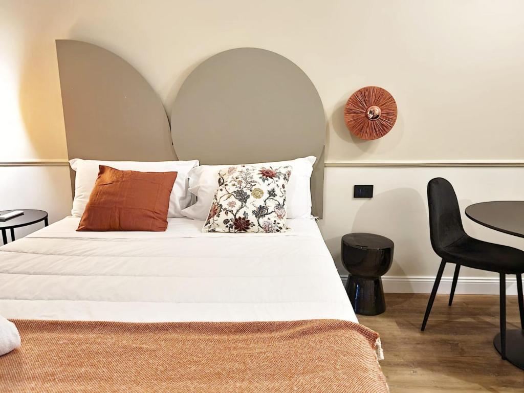 佩斯卡拉TUTTOTONDO的卧室配有带枕头和桌子的白色床