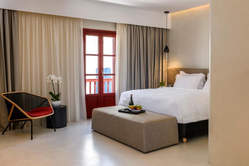 米克诺斯城Mykonos Gem的配有一张床和一把椅子的酒店客房