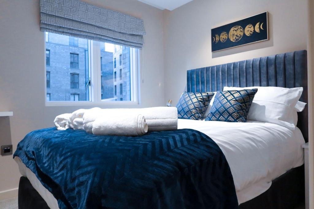 约克City Centre Luxury studio apartment suite with garden view的一间卧室配有一张大床和蓝色床头板