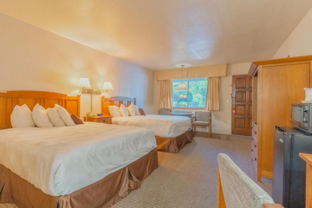 马里波萨Mariposa Lodge的酒店客房设有两张床和电视。