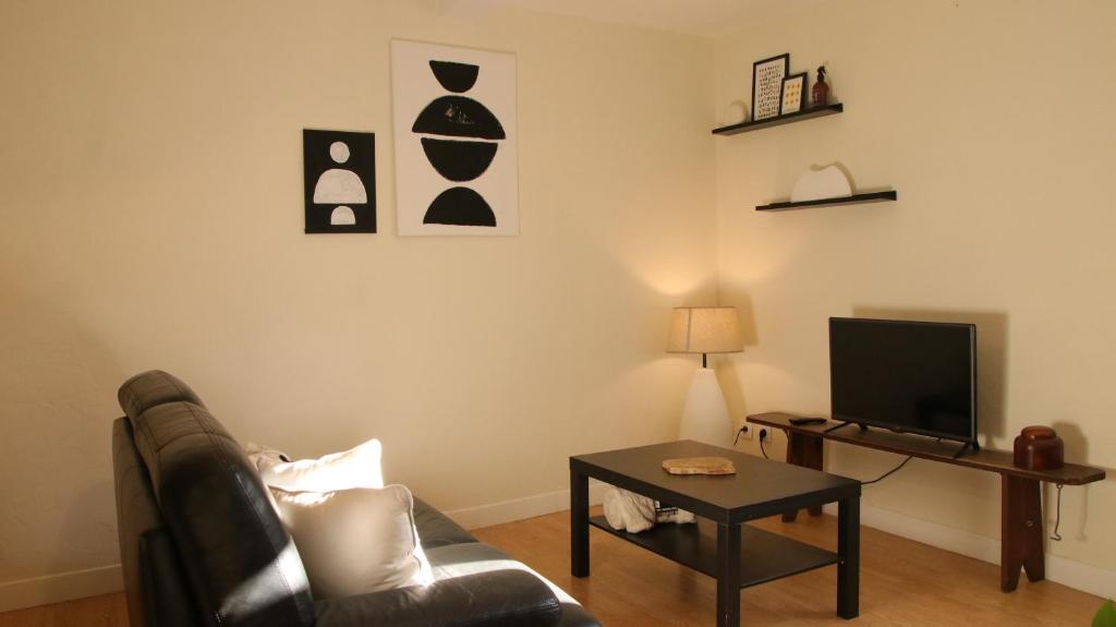 GraulhetMAISON COSY - HYPERCENTRE GRAULHET - 6 PERS的带沙发、桌子和电视的客厅