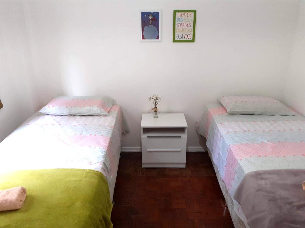 里约热内卢Lindo quarto na Praia de Botafogo的带2张单人床的白色桌子客房