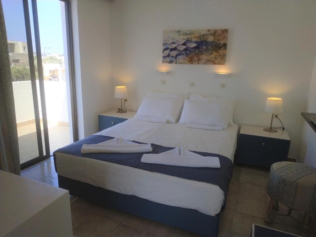 阿彻奇洛斯纳基索斯酒店的一间卧室配有带白色床单和枕头的床。