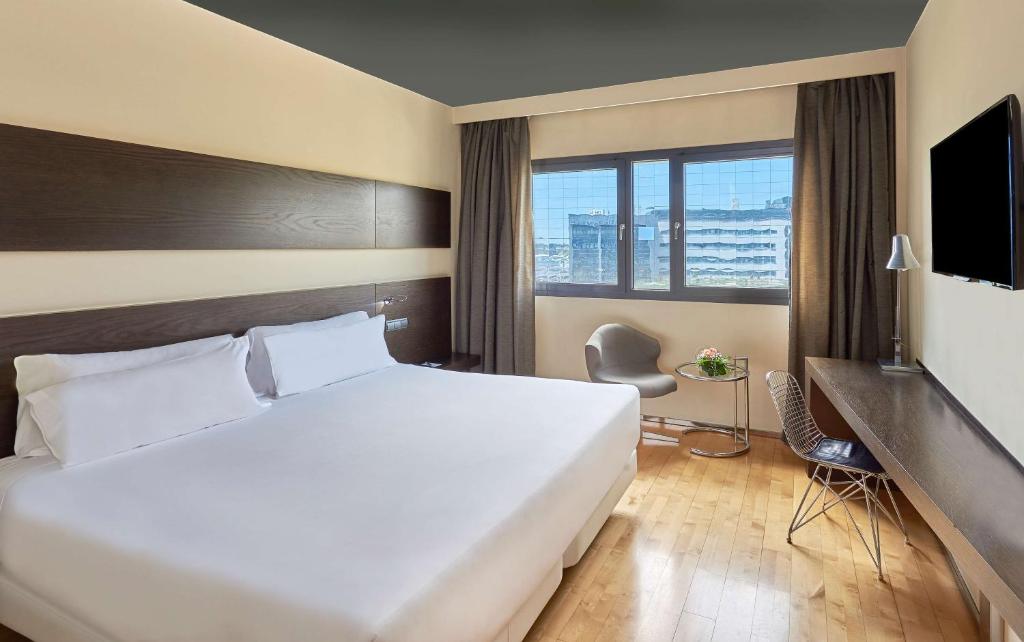 马德里NH马德里拉斯塔布拉斯酒店的一间设有大床和窗户的酒店客房