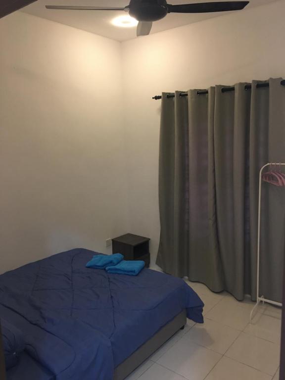 古晋Fadi's Guesthouse at Bandar Baru Samariang的一间卧室配有一张床和吊扇